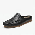 Black leather mules on a white background