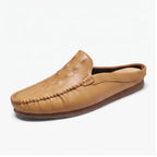 Tan leather mules on a white background