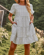White and black dotted A-line mini sundress with short sleeves.