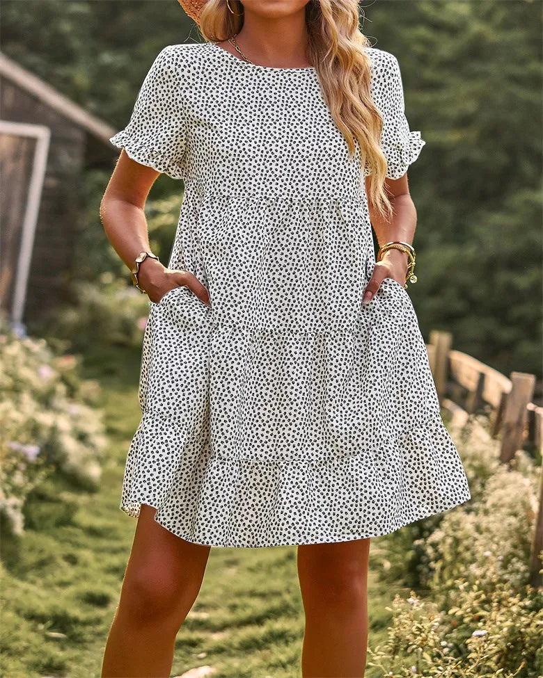 White and black dotted A-line mini sundress with short sleeves.