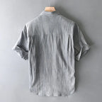 Gray short-sleeve shirt on a hanger against a gray background