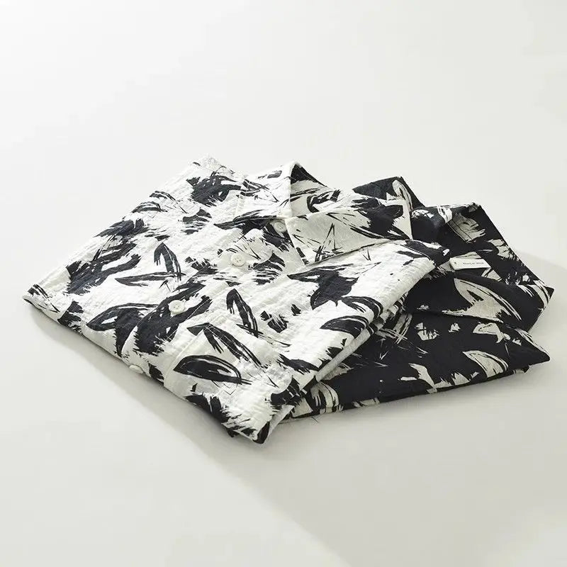 Folded black and white patterned shirts on a light gray background