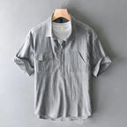 Gray short-sleeve shirt on a hanger against a gray background