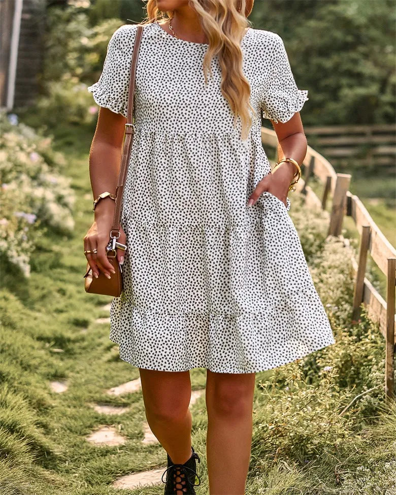White short-sleeve A-line sundress with black polka dots and ruffle trim.