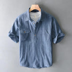 Blue striped shirt on a hanger against a gray background