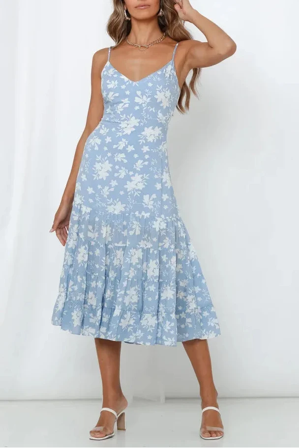 Woman wearing a light blue floral dress against a white background