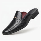 Black leather mules on a white background