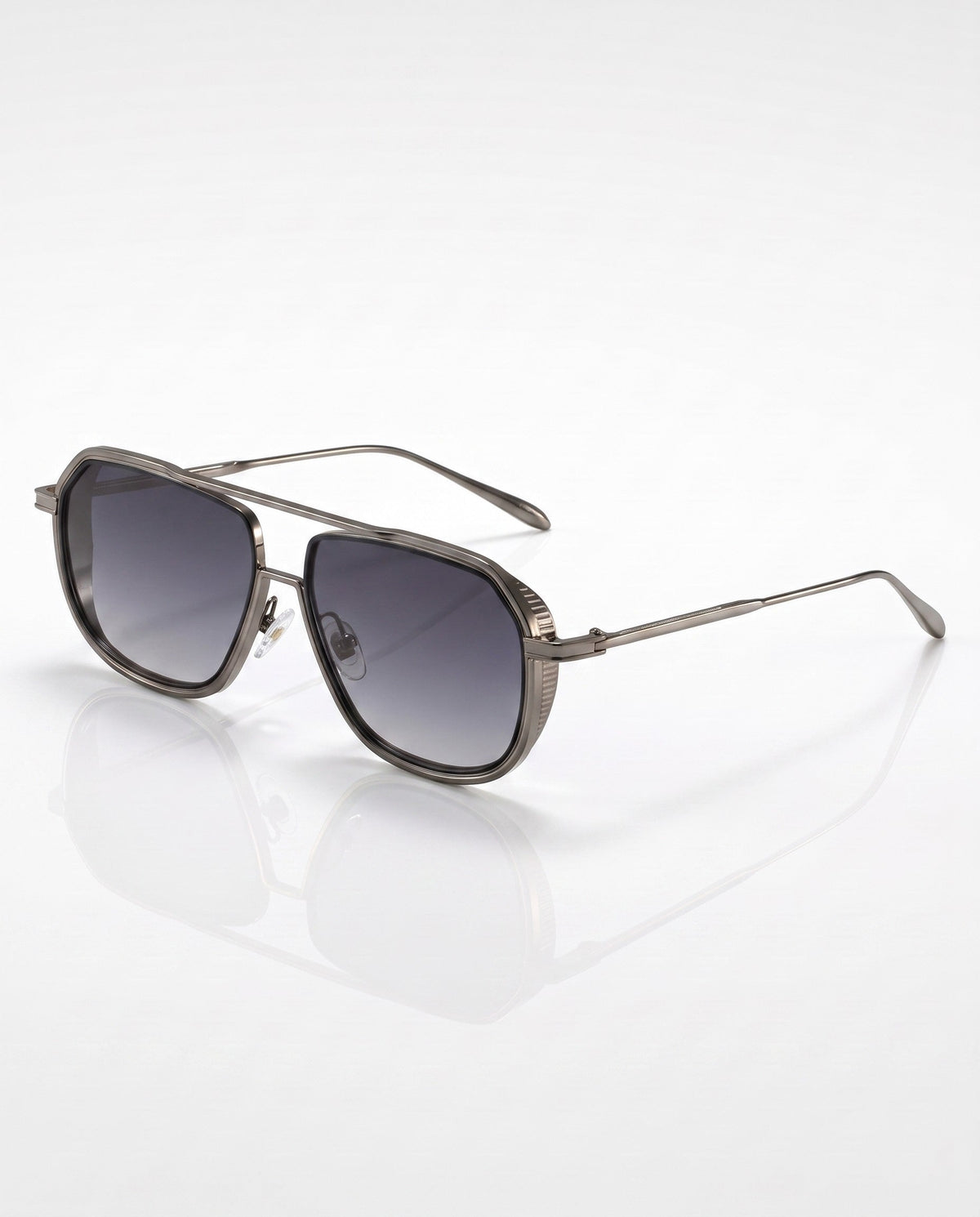 Flat lay of gunmetal gray aviator sunglasses with gradient gray lenses and textured side shields on a white surface.