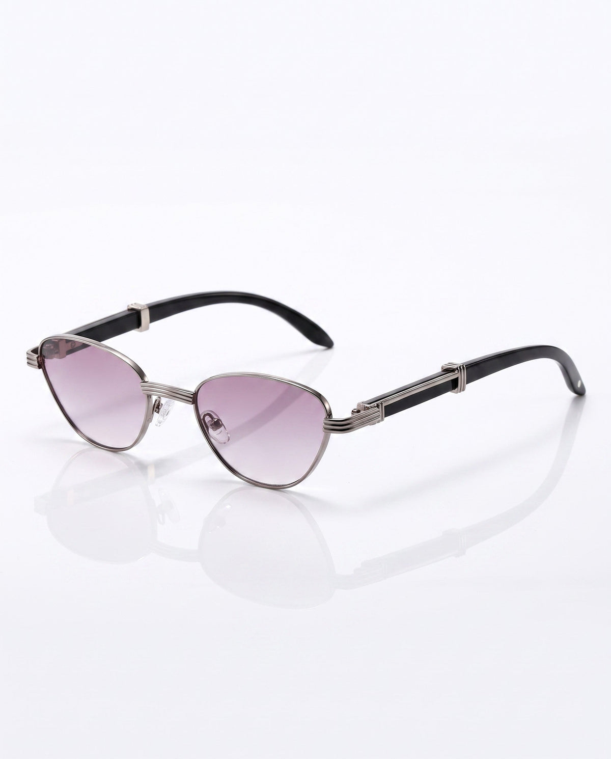 Silver metal framed cat-eye sunglasses with gradient purple lenses and black arms, resting on a reflective white surface.