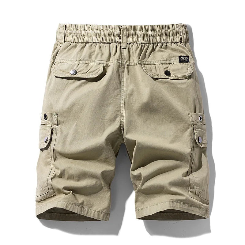 Back view of tan cotton cargo shorts with an elastic waistband, two flap back pockets, and two side cargo pockets.