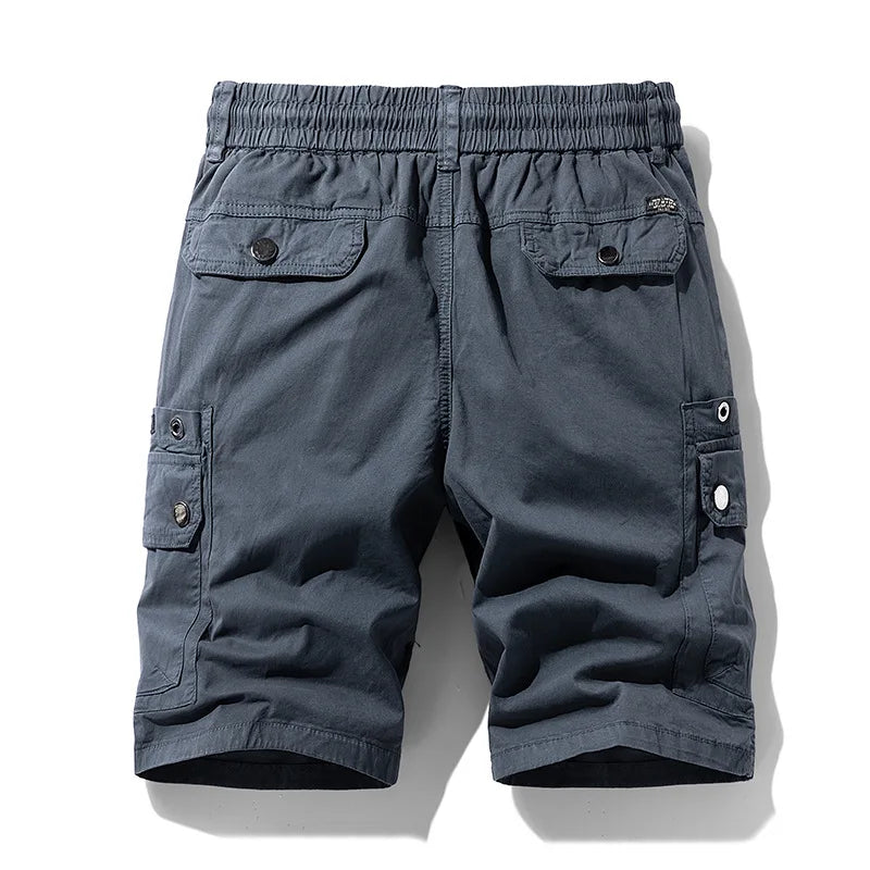 Back view of dark grey cargo shorts with an elastic waistband and four buttoned flap pockets, displayed flat.