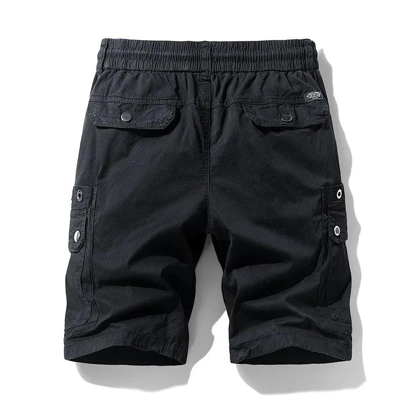 Black cargo shorts from the back, featuring an elastic waistband, two flap pockets, and two side cargo pockets with grommets.