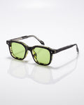 Dark square frame sunglasses with green lenses and light green mottled inner lining, angled on a white surface.