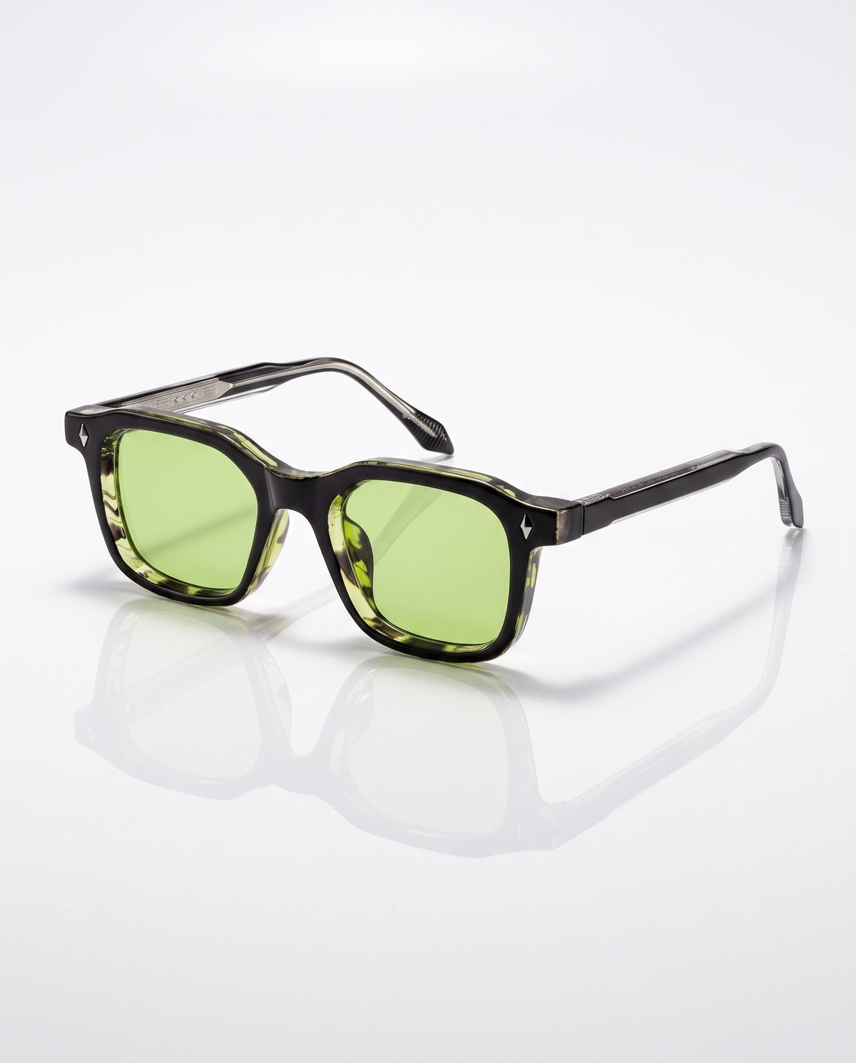 Dark square frame sunglasses with green lenses and light green mottled inner lining, angled on a white surface.