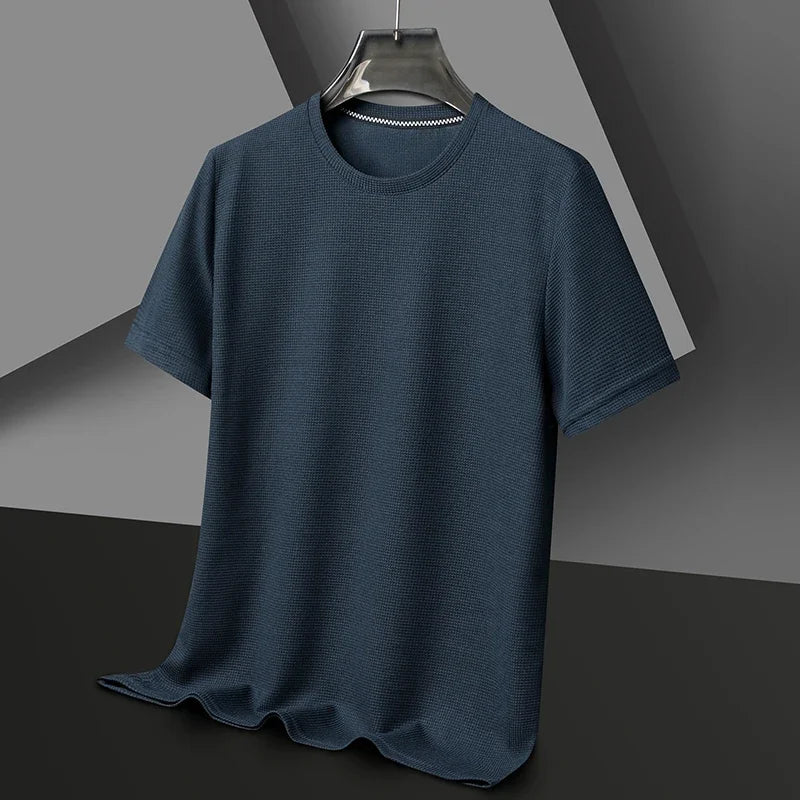 Dark blue waffle knit short-sleeved crewneck shirt displayed on a hanger against a gray and black background.