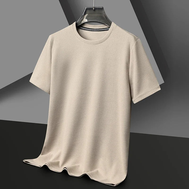 Light beige waffle-knit crewneck shirt on a dark hanger, showcasing its textured fabric and relaxed fit against a gray background.