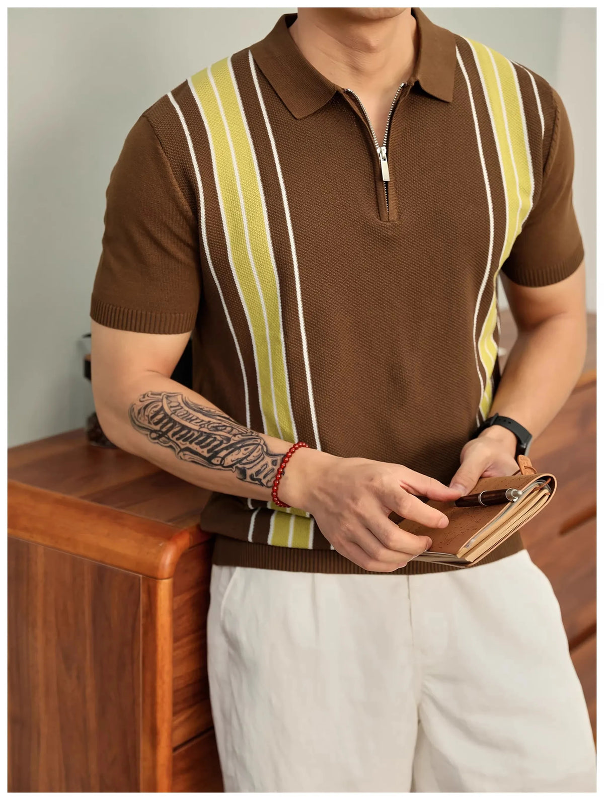 Man wearing a brown knit polo shirt with vertical yellow and white stripes and a silver zipper collar.