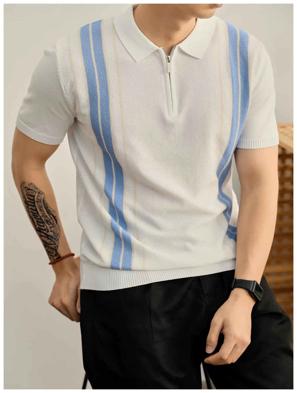 Man wearing a white knit polo shirt with light blue and beige vertical stripes, featuring a partial zipper.