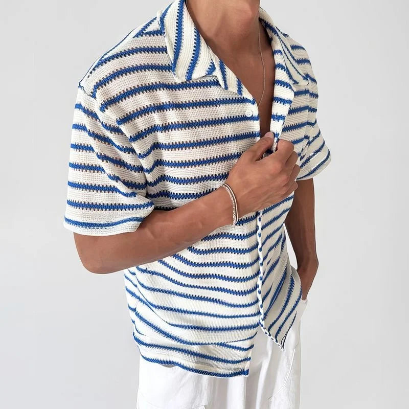 Man wearing a short-sleeve, open knit shirt with blue and white stripes, paired with white pants.