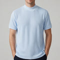 Blue knit shirt on an off-gray studio background