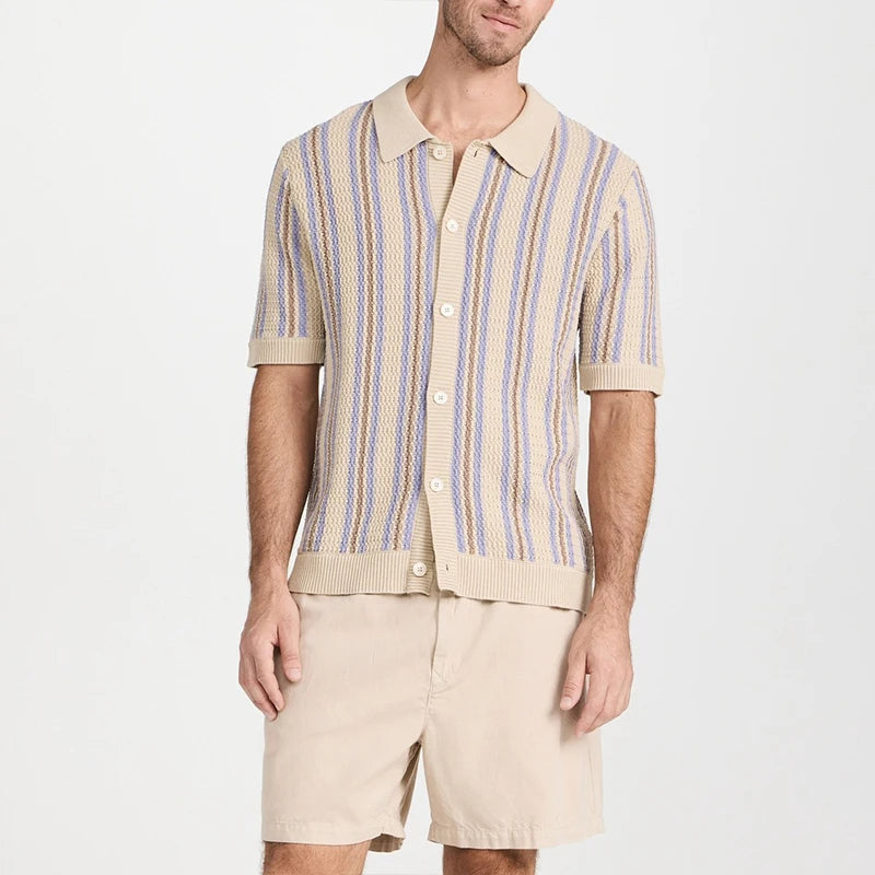 Man wearing a short-sleeve button-up knit shirt with beige, light blue, and brown vertical stripes over beige shorts.