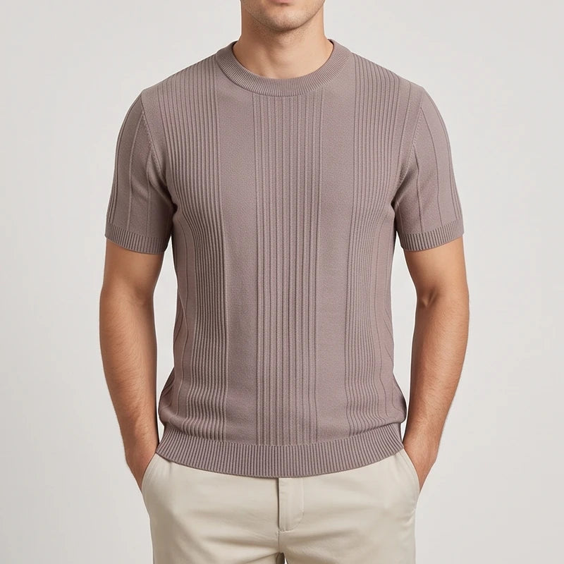 Man wearing a slim-fit, taupe knit short sleeve crewneck shirt with vertical ribbed texture and light pants.