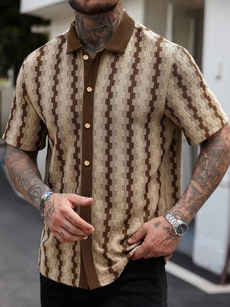 Man wearing a beige and brown knit short-sleeve collared shirt with a geometric patterned texture and brown buttons.