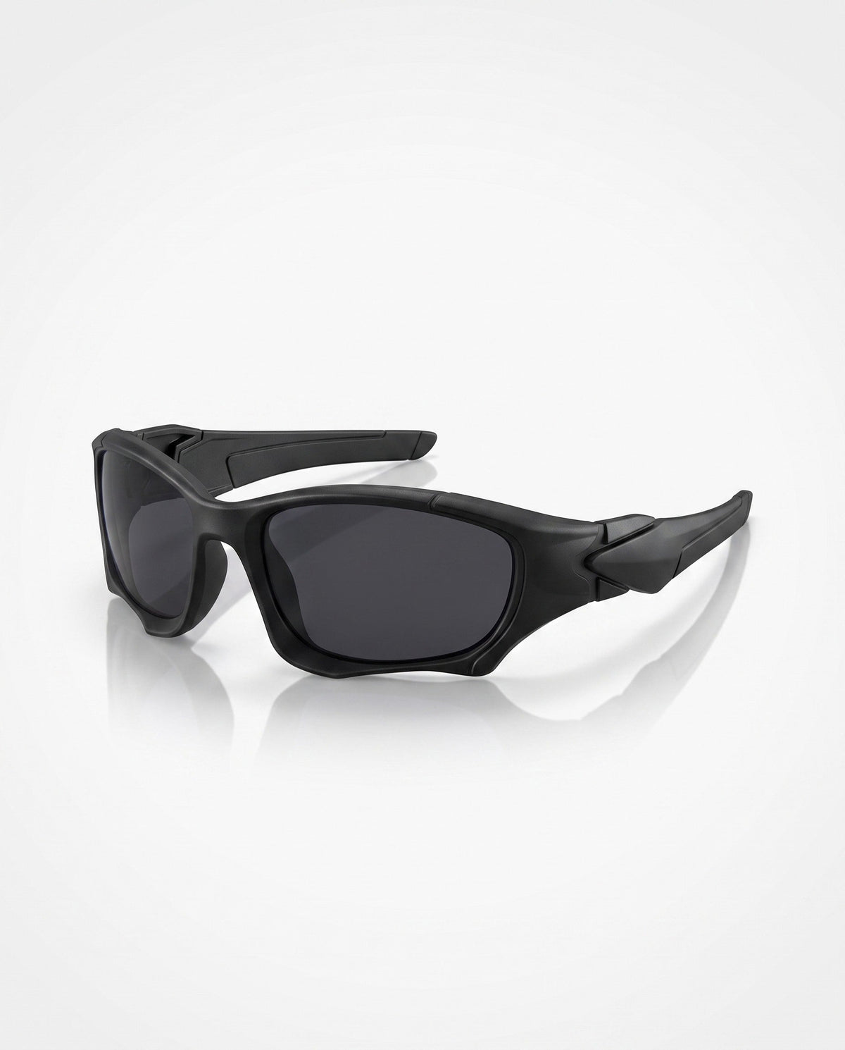 Matte black sports sunglasses with dark lenses lie angled on a reflective white surface, showcasing their sporty frame.