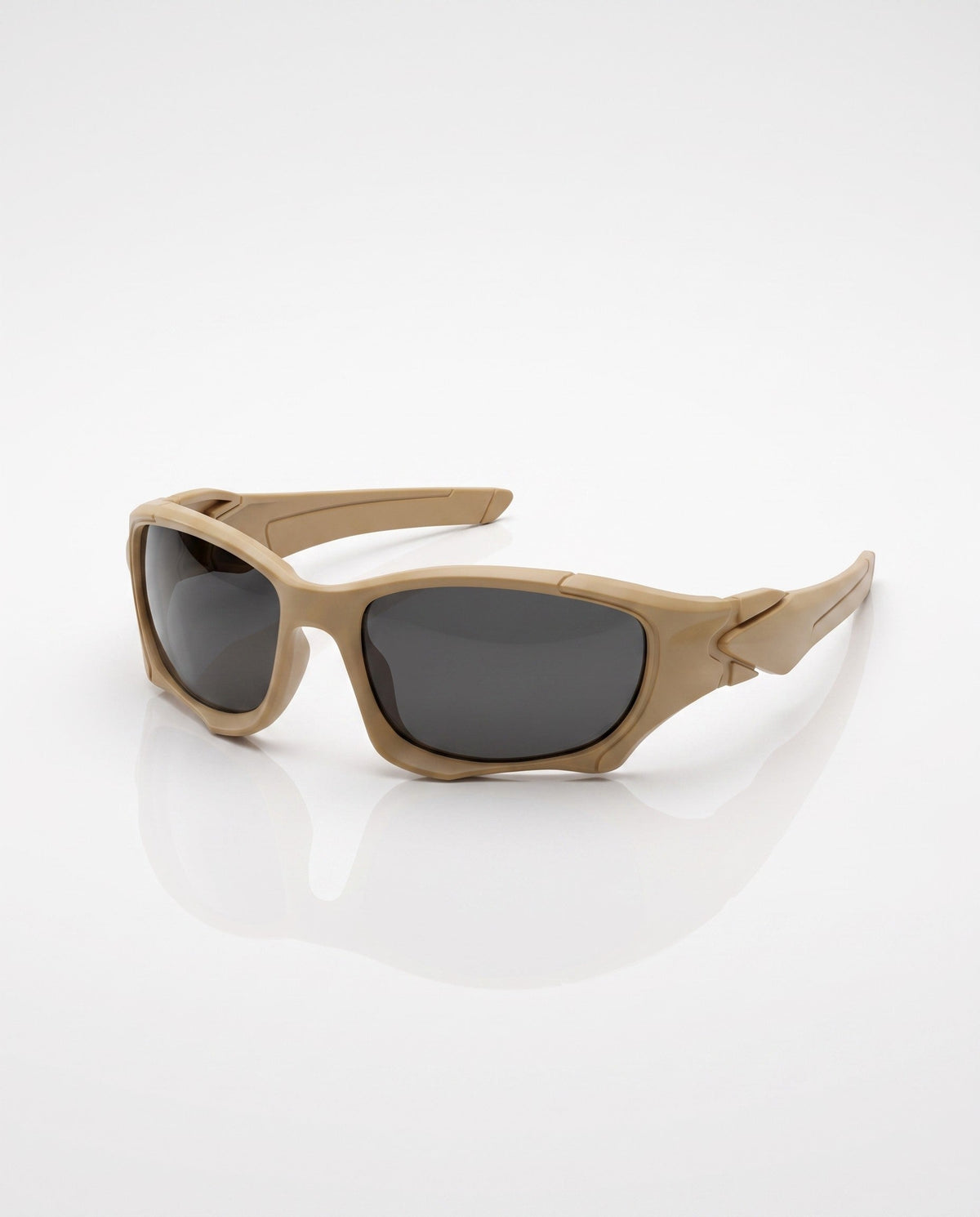 Tan sports sunglasses with dark lenses lie on a reflective white surface, showing their curved frame design.