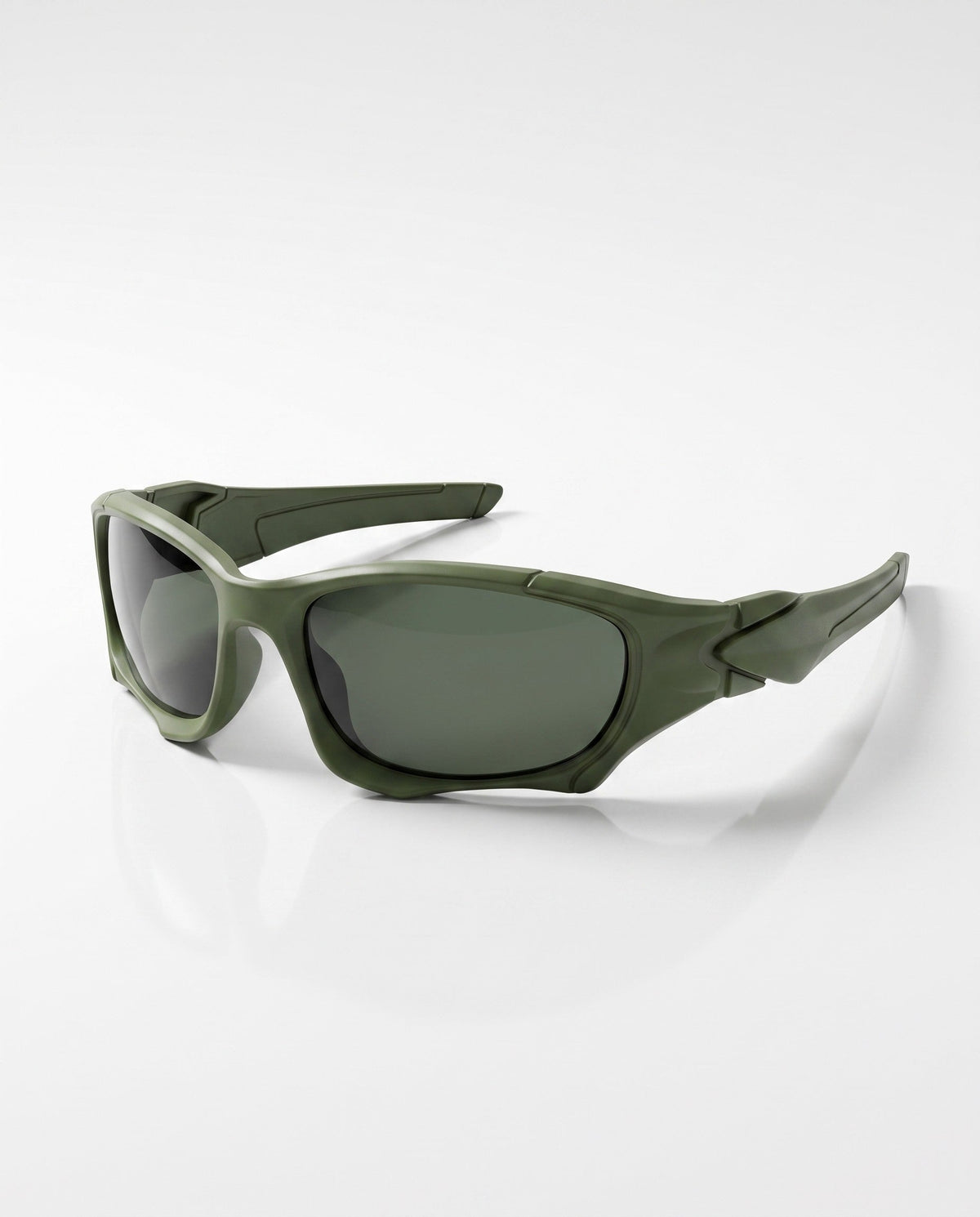 Matte dark green sports sunglasses with dark lenses and sculpted frames are positioned on a white surface.