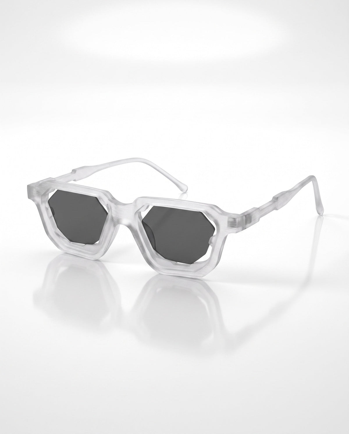 Translucent white angular sunglasses with octagonal dark grey lenses, casting a slight reflection on a bright white surface.