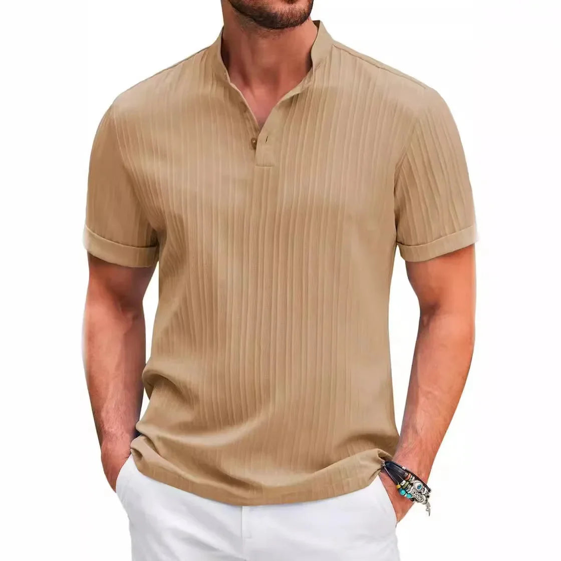 Man wearing a tan short-sleeved shirt with vertical pleats and a band collar, paired with white pants.