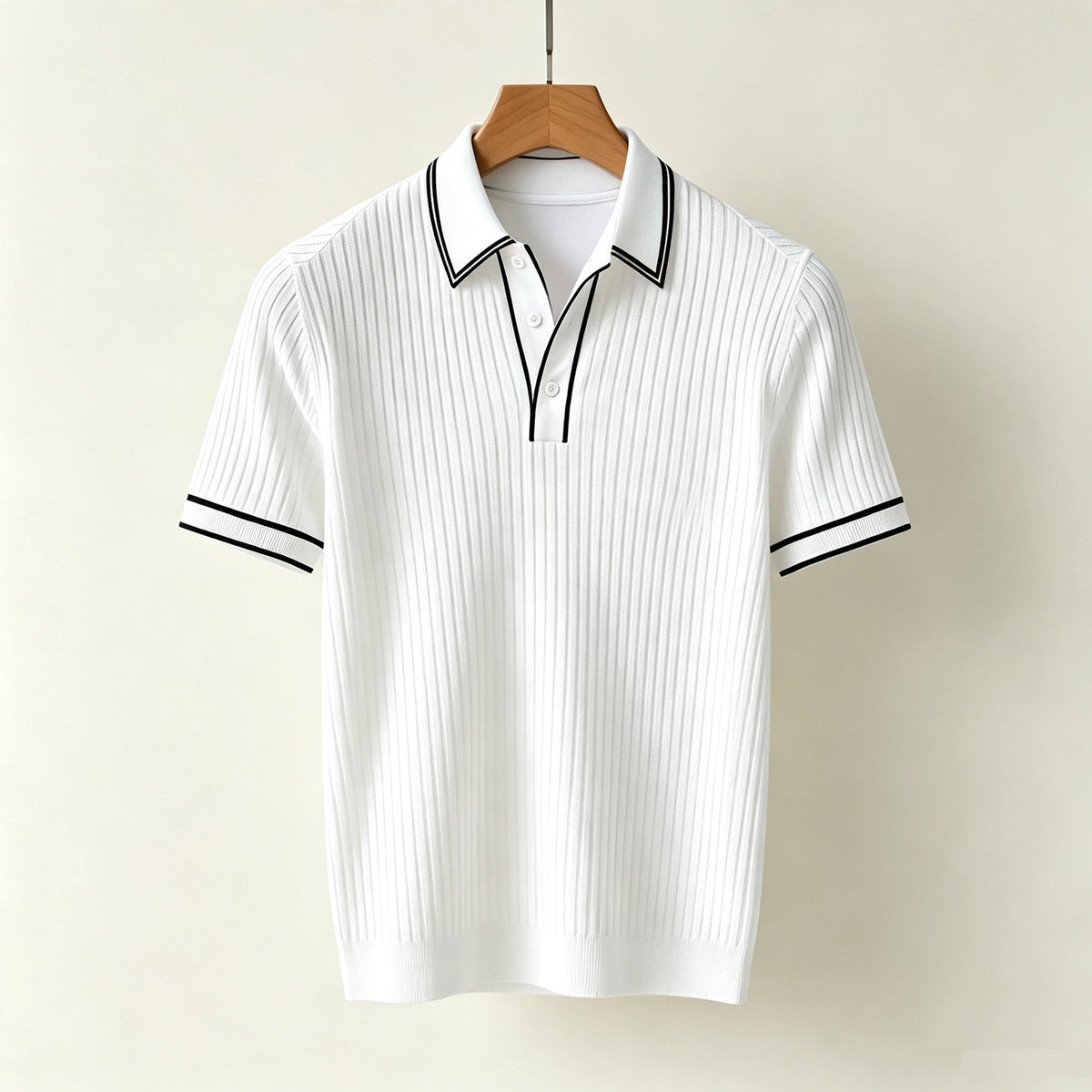 White ribbed knit polo shirt with black trim on the collar and sleeve cuffs, hanging on a wooden hanger.