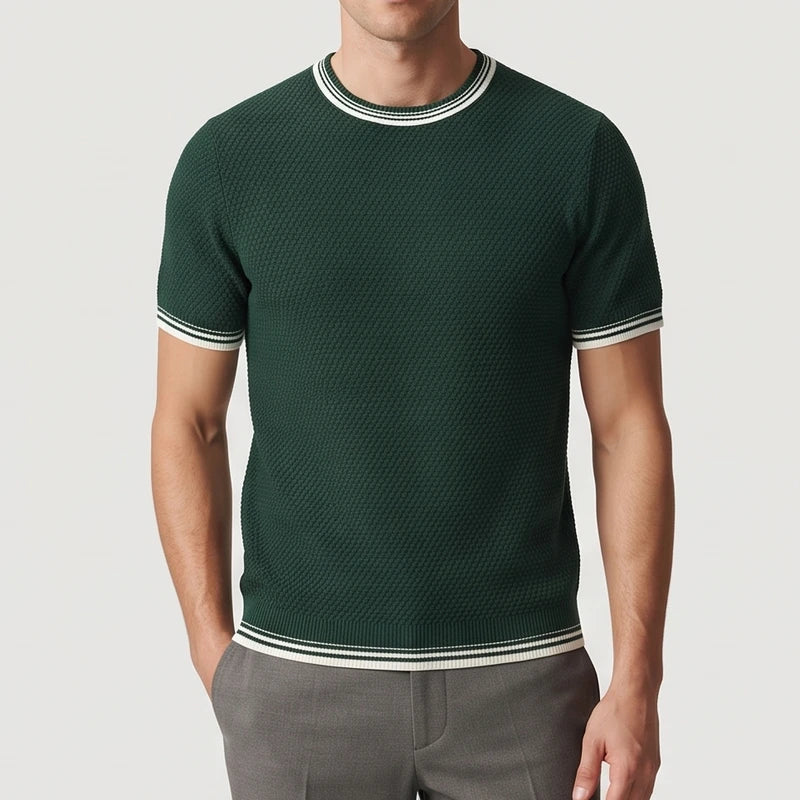 Man wearing a dark green textured knit shirt with white and dark green striped trim on the collar, sleeves, and hem.