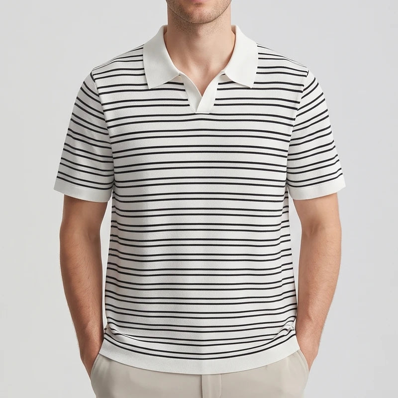 Man wearing a short-sleeve white and black striped knit polo shirt with an open collar and beige pants.