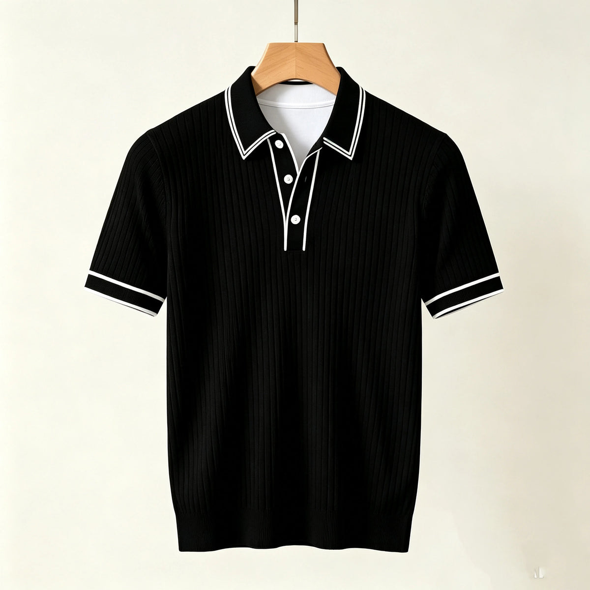 Black ribbed knit short-sleeved polo shirt with white striped collar, placket, and cuffs, hanging on a wooden hanger.