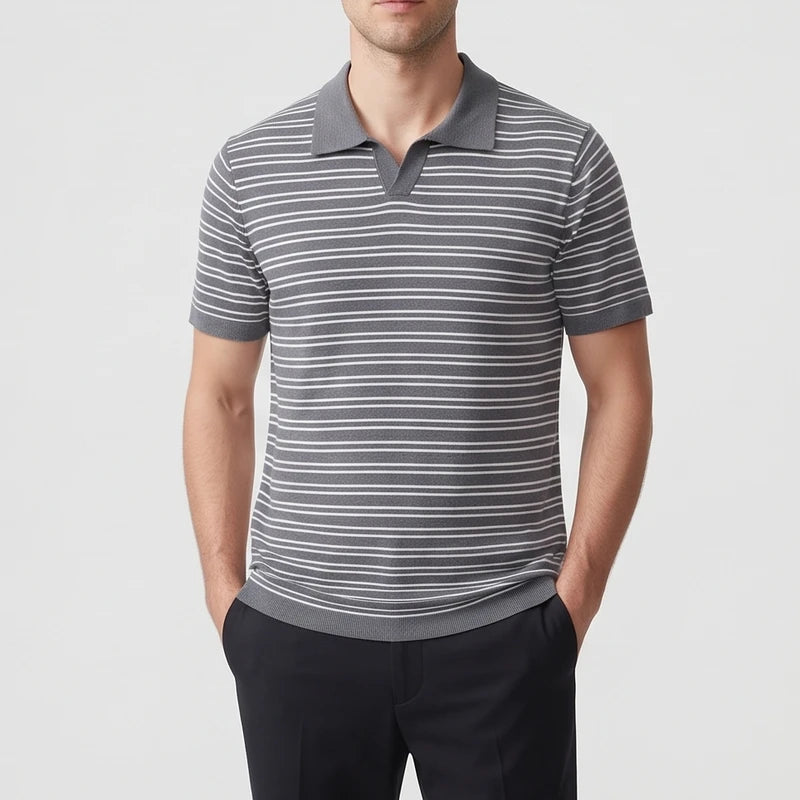 Man wearing a short-sleeve gray and white striped polo shirt with a knit collar, standing with hands in pockets.