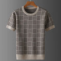 Short sleeve knit shirt in beige and dark brown geometric checkerboard pattern, with ribbed trim, hanging on a wooden hanger.