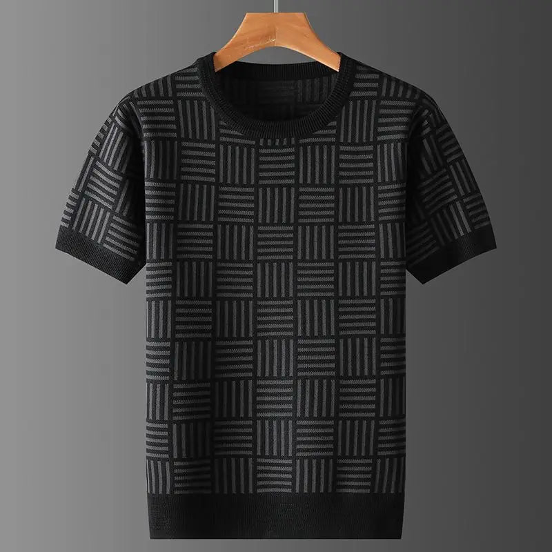 Black and dark grey short sleeve knit shirt with a geometric checkered pattern, hanging on a wooden hanger.