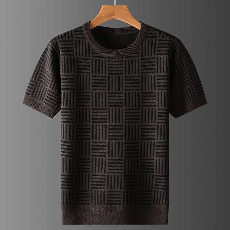 Dark brown knit short sleeve shirt with a geometric checkered pattern, hanging on a wooden hanger against a gray background.