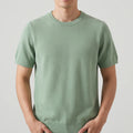 Green sweater on an off-gray studio background